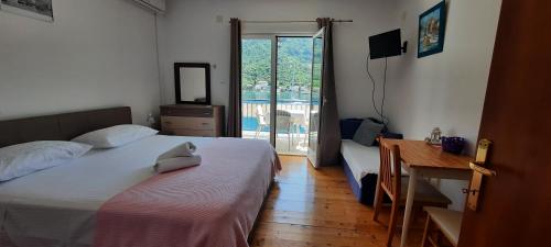 sypialnia z 2 łóżkami, biurkiem i oknem w obiekcie Apartments Lampalo w mieście Okuklje