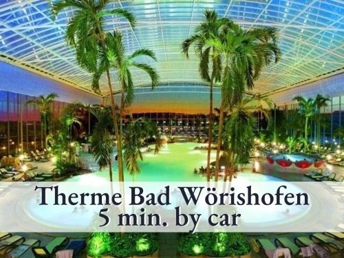 a large indoor mall with palm trees and a ceiling at Tolle Zweiraum-Ferienwohnung in bester Lage l Innenstadtnähe l 1 Minute zum Bahnhof l TV l Free-WLAN l Keine Küche l Willkommen im Hallo!-Apartment 4 in Bad Wörishofen