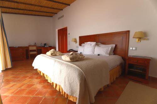 a bedroom with a bed with two cats laying on it at Herdade dos Grous in Albernoa