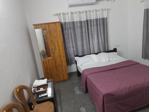 - une chambre avec un lit et une armoire en bois dans l'établissement The Camp Club Beach Villa, à Payyannūr