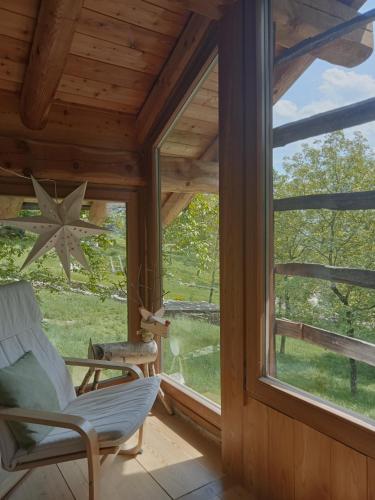 a room with a window and a chair on a porch at Baita del noce in Mollia