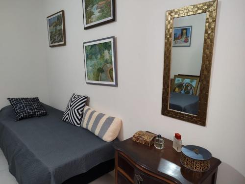 a bedroom with a bed and a mirror and a table at Casa 2 quartos com churrasqueira no centro de Serra Negra in Serra Negra