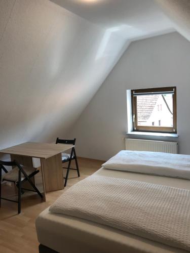 a bedroom with a bed and a table and a window at DZ im Haus Maja in Holzkirchen