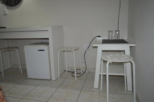 eine Küche mit zwei Hockern, einem Tisch und einer Theke in der Unterkunft Albion in Athen