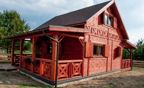 a red barn with a black roof at Dobre Miejsce na Roztoczu in Huta Różaniecka