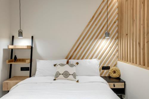 a bedroom with a white bed with a wooden headboard at Argento urban apartment (sphere) in Ermoupoli