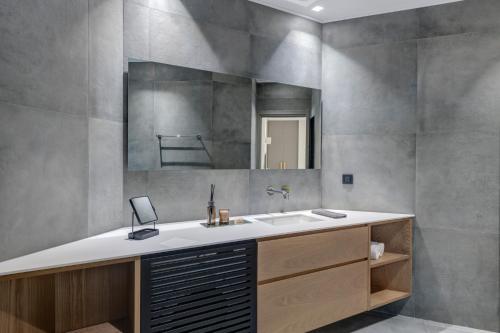 a bathroom with a sink and a mirror at Argento urban apartment (sphere) in Ermoupoli