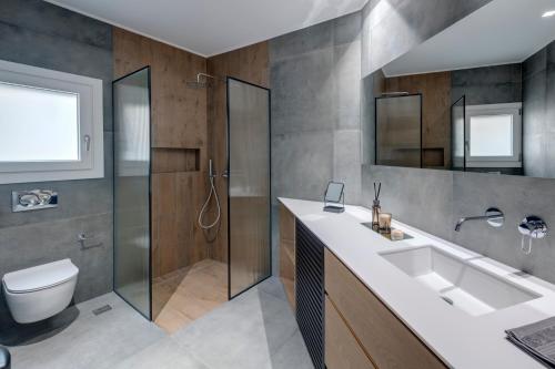 a bathroom with a sink and a shower and a toilet at Argento urban apartment (sphere) in Ermoupoli