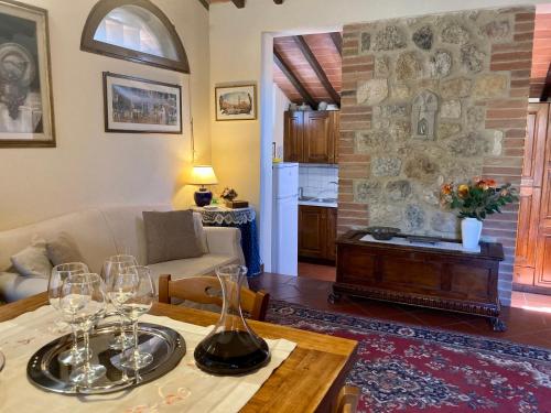 una sala de estar con una mesa con copas de vino. en Monteriggioni Castello, en Monteriggioni