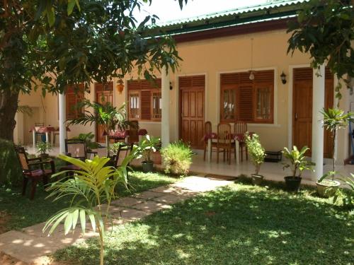 a house with a garden and a patio at Tissa Resort in Tissamaharama