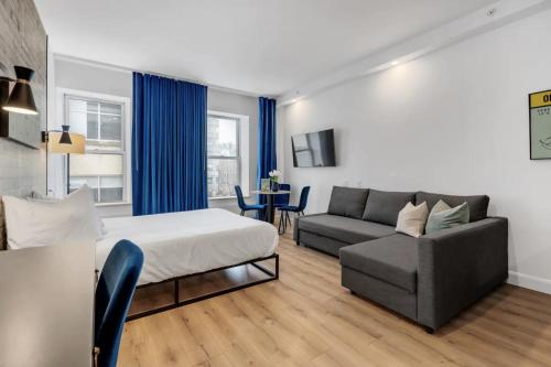 Un dormitorio con una cama, un sofá y una mesa. en INITIAL - MONOPOLY - Centre-Ville de Quebec, en Quebec