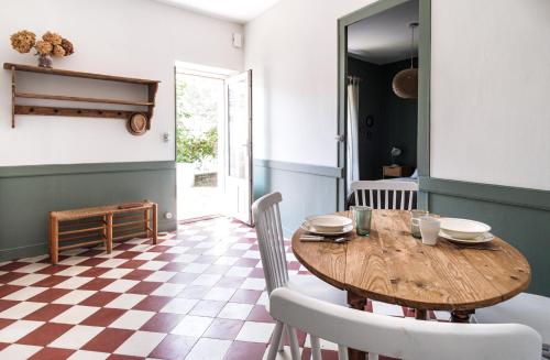 a dining room with a wooden table and chairs at Le clos Poujeau 15 mns centre Bordeaux in Pessac
