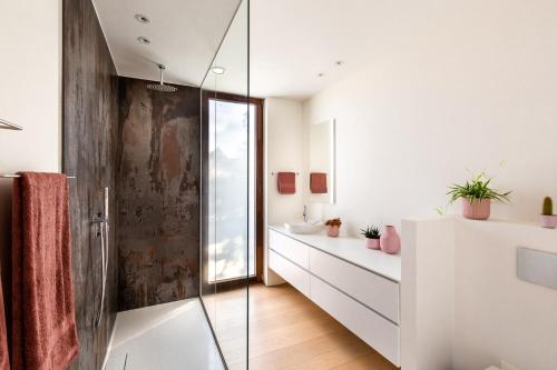 a bathroom with a glass shower and a sink at Huis van Hout - architectenwoning met grote panorama tuin - design hot tub optioneel in Herk-de-Stad