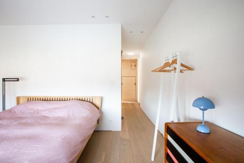 a bedroom with a bed and a wooden dresser at Huis van Hout - architectenwoning met grote panorama tuin - design hot tub optioneel in Herk-de-Stad