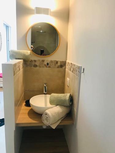 une salle de bain avec un lavabo et un miroir dans l'établissement Petite Bergerie, à Bonifacio