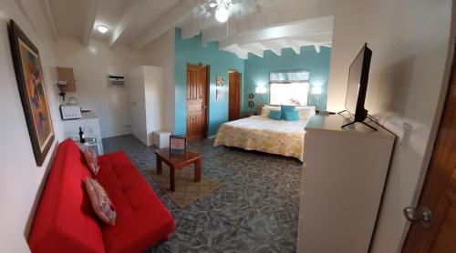 um quarto de hotel com uma cama e um sofá vermelho em Vista Canyon Inn em Santa Ana
