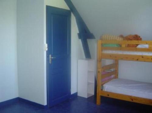 a blue door in a room with a bunk bed at Maison avec jardin et plage de sable fin accessible à pied à 300m in Saint-Coulomb