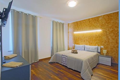 1 dormitorio con 1 cama y TV. en Palazzo Richard Leone, en Udine