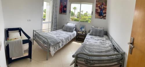 - une chambre avec 2 lits et une fenêtre dans l'établissement Marina Golf Asilah, à Assilah