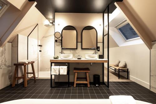 La salle de bains est pourvue de 2 lavabos et de 2 miroirs. dans l'établissement Le Celtique & Spa, à Carnac