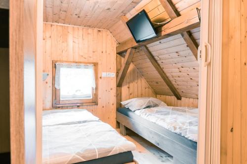 a bedroom with a bed and a tv in a cabin at Počitniška hiška Jrga in Bovec