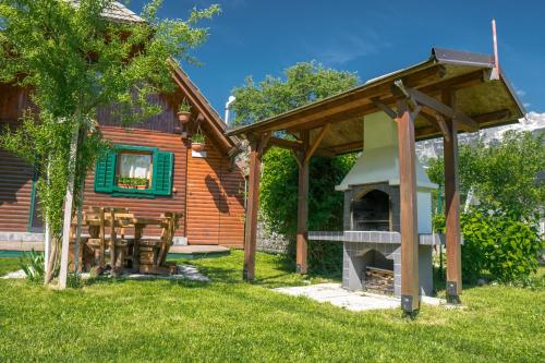 a wooden cabin with a pizza oven in the yard at Počitniška hiška Jrga in Bovec