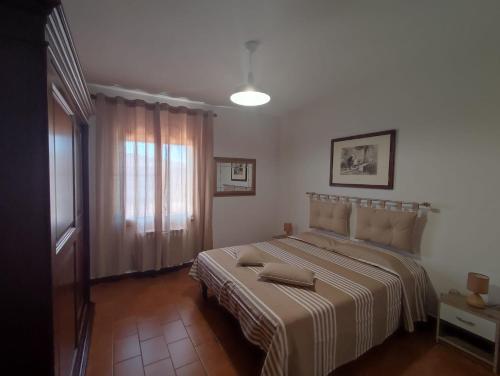 a bedroom with a large bed with a striped blanket at Sole&Luna in San Teodoro