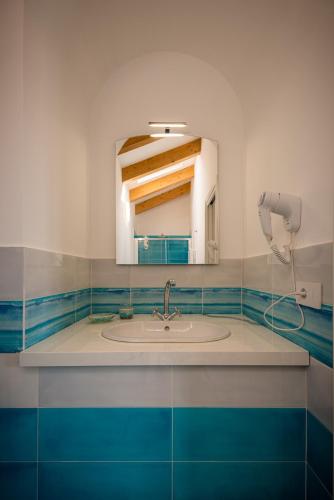 un bagno con lavandino e specchio di Palazzo San Giovanni - near Path of the Gods a Pianillo