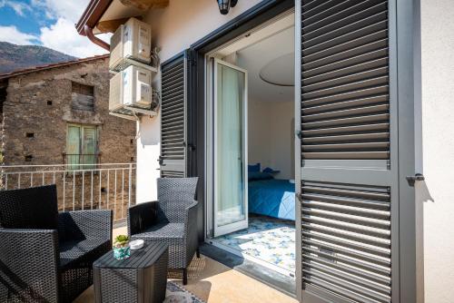einen Balkon mit Stühlen und eine Schiebetür mit einem Schlafzimmer in der Unterkunft Palazzo San Giovanni - near Path of the Gods in Pianillo