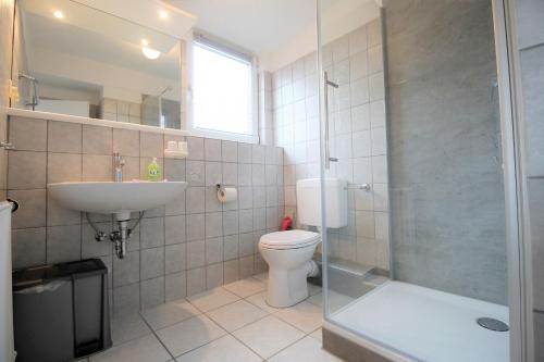 a bathroom with a toilet and a sink and a shower at Haus Barbara - Schwimmbad und Sauna im Haus- Whg 5 in Grömitz