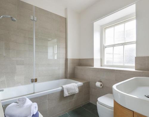 a bathroom with a tub and a toilet and a sink at The Terrace 4 in Padstow