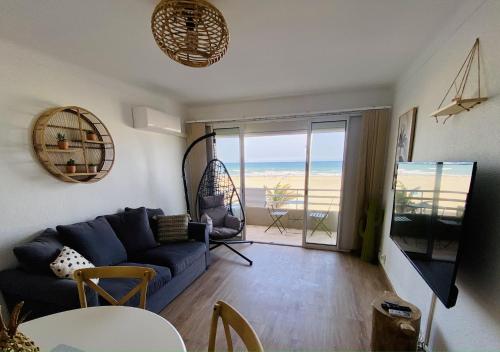 een woonkamer met een blauwe bank en uitzicht op de oceaan bij "EDEN" Exceptionnel! Vue mer 10m de la plage parking privé gratuit à 100m in Canet-en-Roussillon