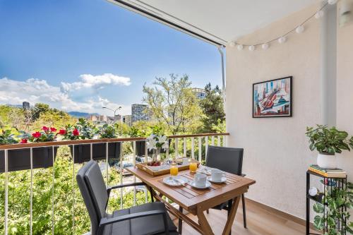 een balkon met een houten tafel en stoelen en uitzicht bij Exquisite Couples Delight with free bikes & parking in Split