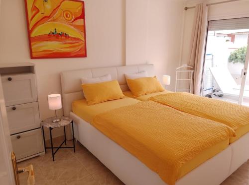 a bedroom with a bed with yellow sheets and a window at Apartamentos Vista Laurisilva in Puerto de la Cruz