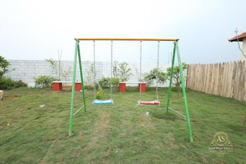 a playground with swings in a yard at AS Garden Villa in Ranipet