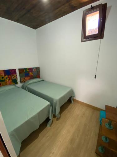 2 camas en una habitación con ventana en Vivienda Vacacional Casa Lola, en Taibique