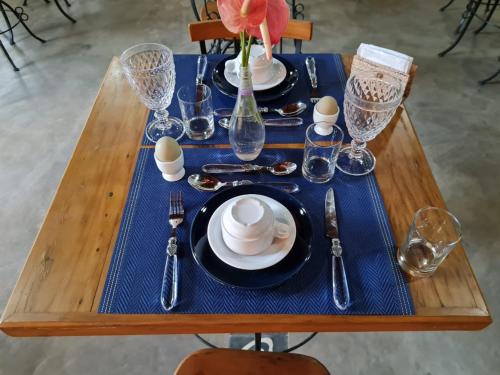 a table with a blue table cloth and plates and silverware at Pousada Serra Morena in Serra do Cipo