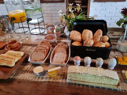 a table topped with bread and pastries on a table at Pousada Serra Morena in Serra do Cipo