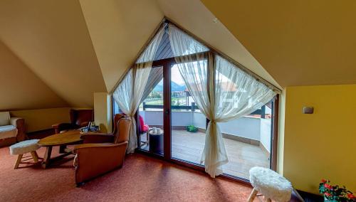 a room with a large window with a view of a balcony at Hotel FAMIL - adults only in Bansko