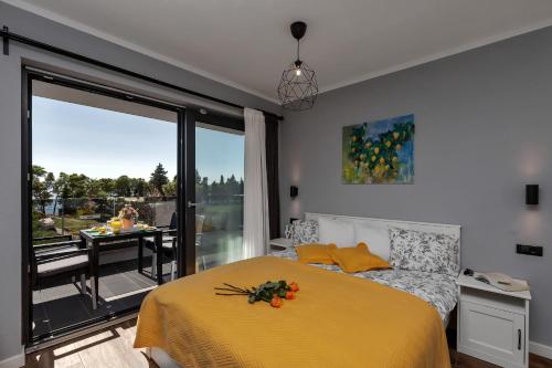 a bedroom with a yellow bed and a balcony at Apartments IKO in Tučepi