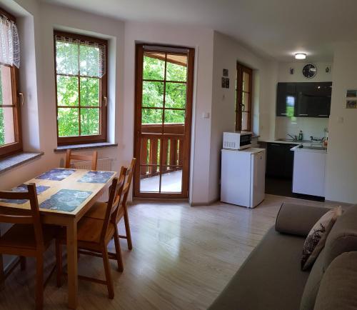 a kitchen and living room with a table and chairs at Apartament Paryski in Karpacz
