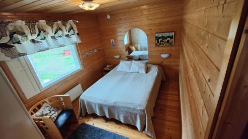 a small bedroom with a bed and a window at Maatilamatkailu Jänisvaara in Kolinkylä