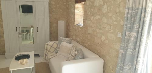 a living room with a white couch and a mirror at Chambre Lily - Au Clos de Parranquet in Parranquet