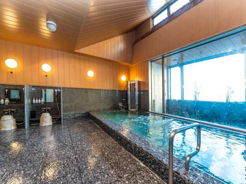 une grande piscine intérieure dans un bâtiment dans l'établissement Hotel Mark-1 Tsukuba, à Tsukuba