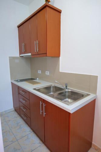 a kitchen with wooden cabinets and a sink at Vila Xhafa in Ksamil