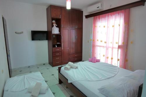 a bedroom with two beds and a dresser and a mirror at Vila Xhafa in Ksamil