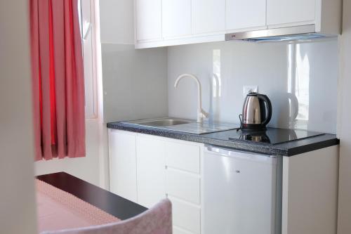 a kitchen with a sink and a kettle on a counter at Vila Xhafa in Ksamil