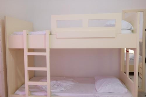two bunk beds with a ladder in a room at Vila Xhafa in Ksamil