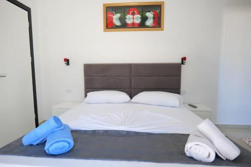 a bedroom with a large bed with blue towels on it at Vila Xhafa in Ksamil