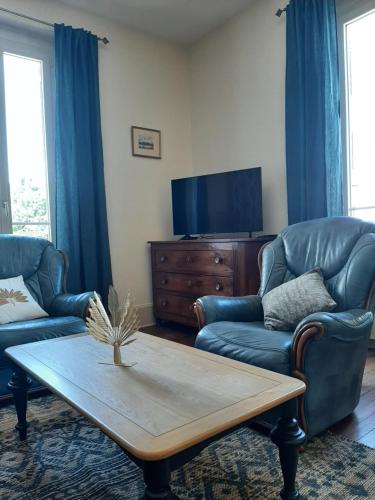 a living room with two couches and a coffee table at La p'tite bourgeoise Auxerroise, demeure de charme. in Auxerre